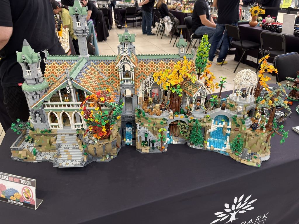 The full LEGO Rivendell build on a display table, with shoppers behind it