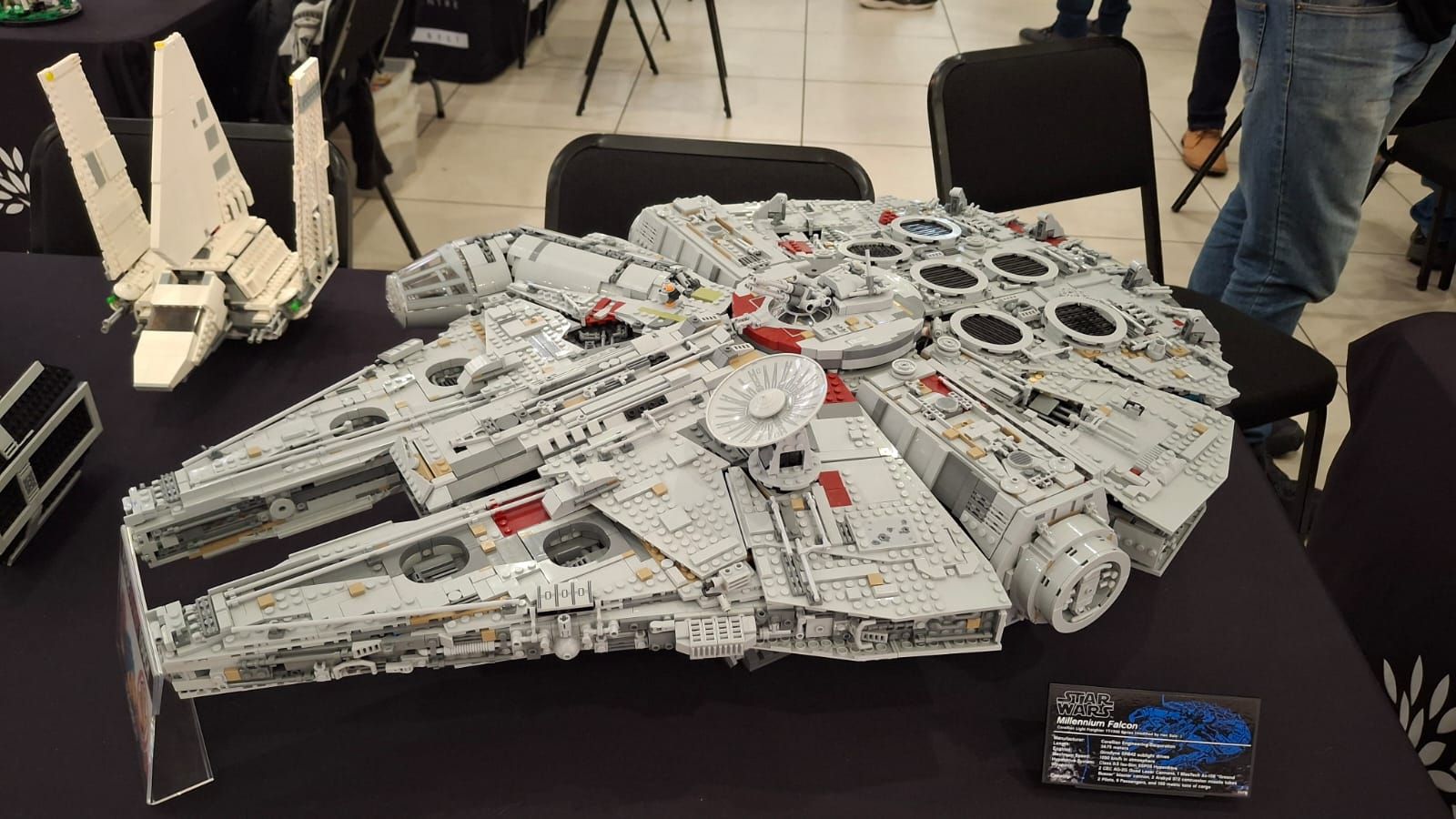 A large LEGO Millennium Falcon and Imperial shuttle on a display table