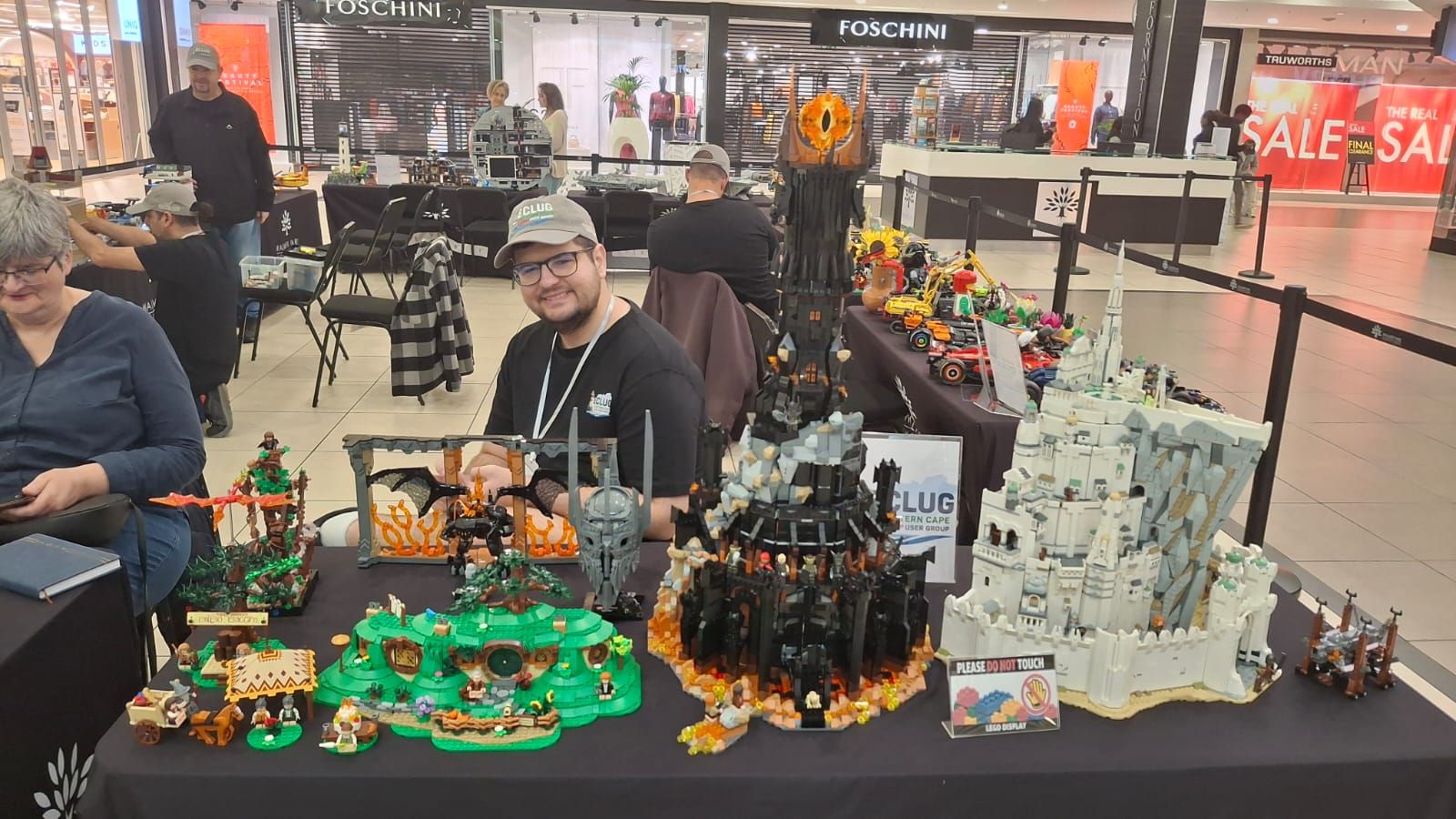 Two ECLug members seated behind a table of Lord of the Rings builds, including Barad-dûr