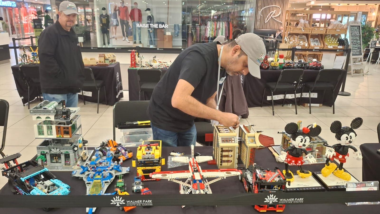 An ECLug member arranging builds on a busy display table